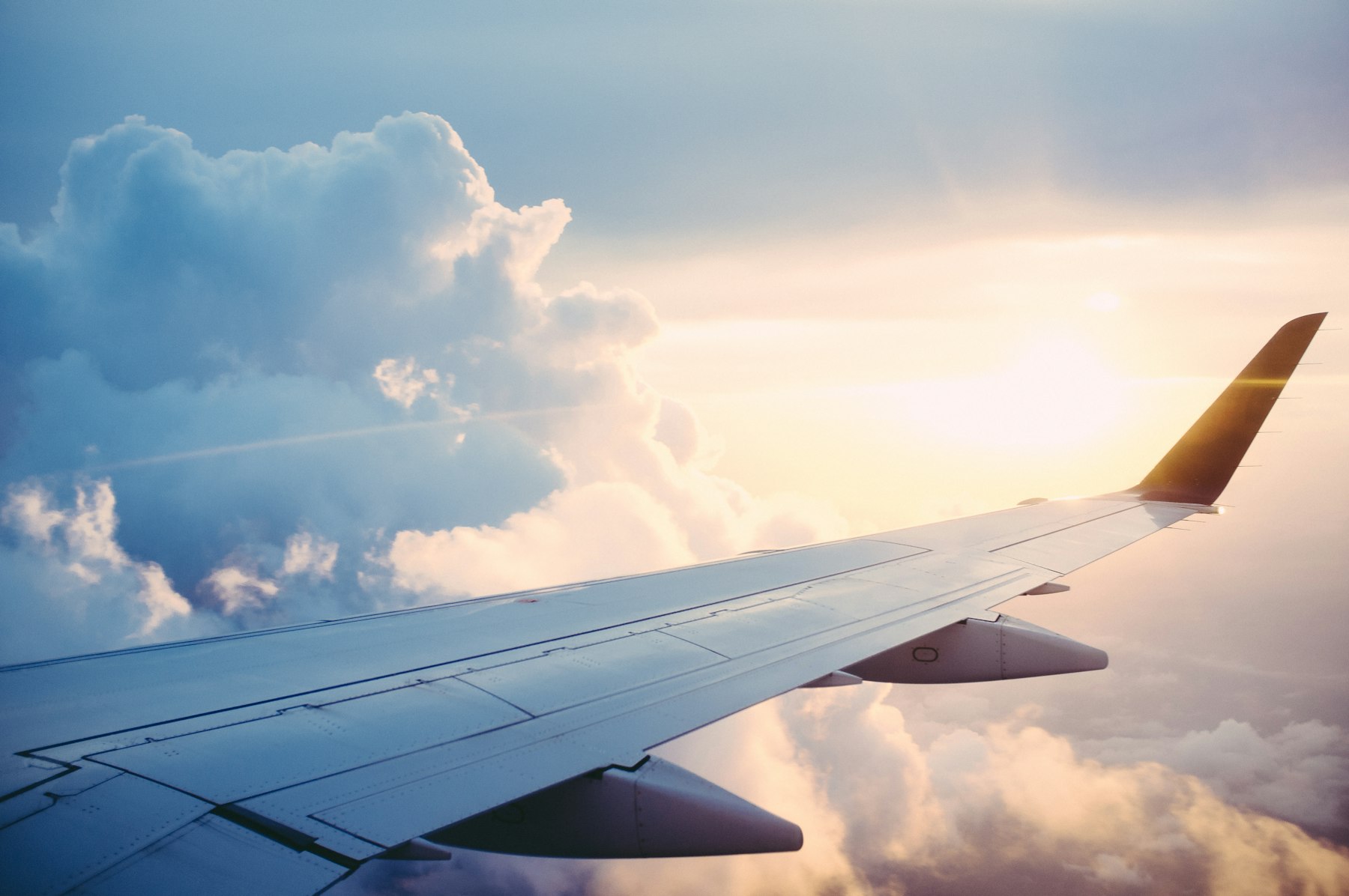 A wing above the clouds at sunset